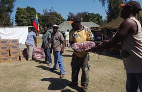 Cadena humana de haitianos para llevar los alimentos a las carpas.