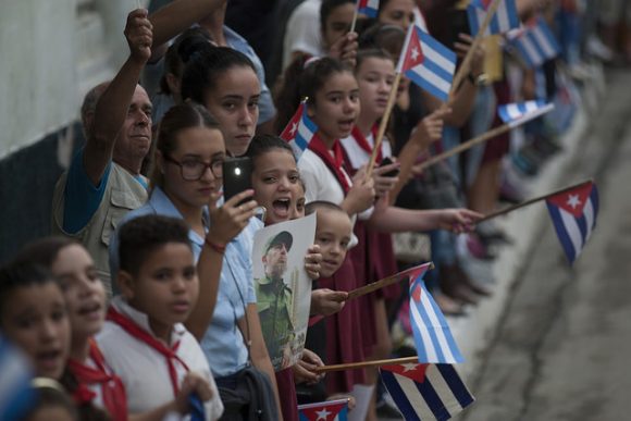 Pioneros cubanos enarbolan banderas cubanas en homenaje a Fidel Castro Ruz