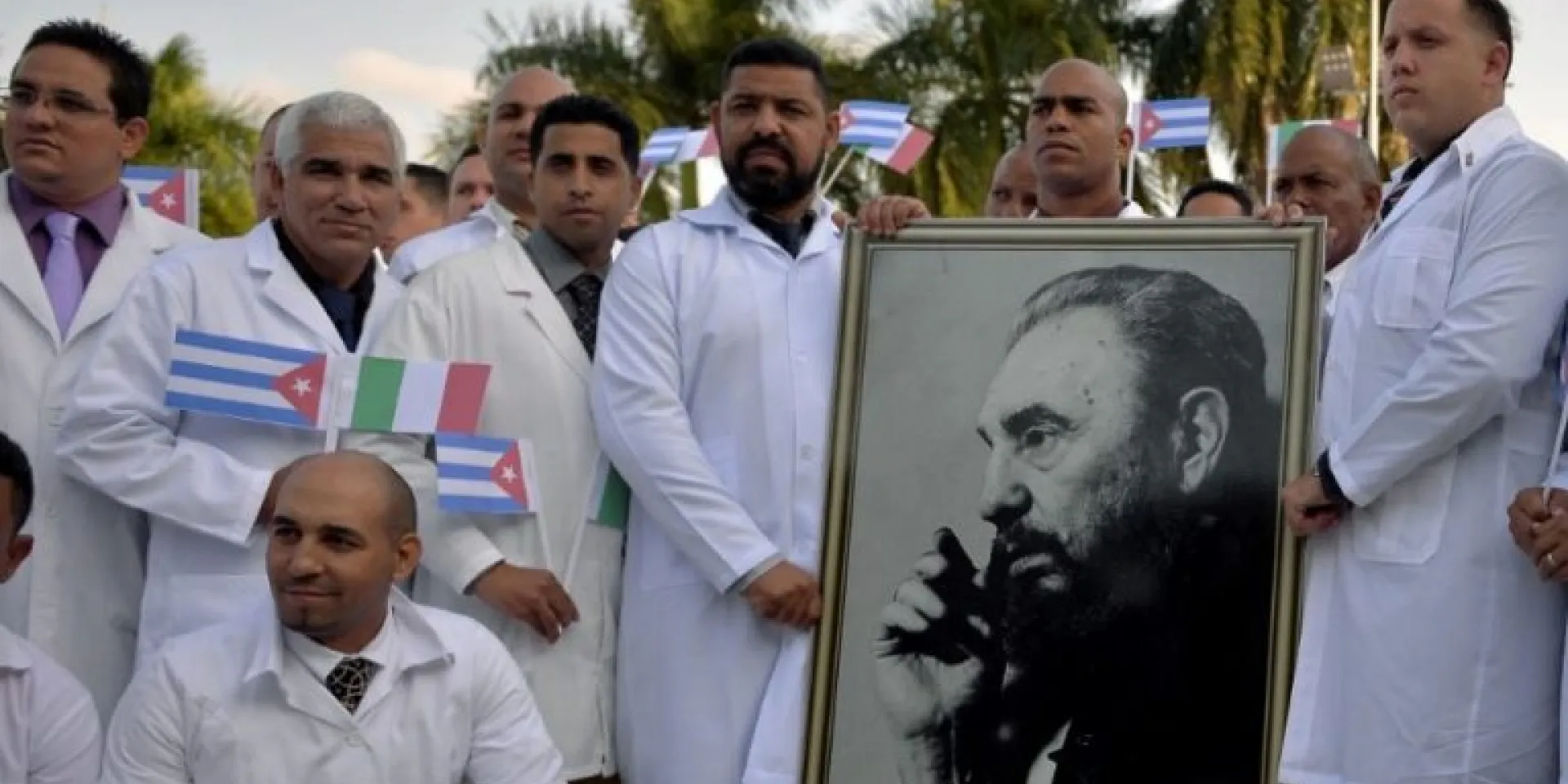 Médicos y enfermeras de la Brigada Médica Internacional Henry Reeve de Cuba posan con un retrato del líder cubano Fidel Castro mientras se despiden antes de viajar a Italia para ayudar en la lucha contra la pandemia del coronavirus COVID-19, en la Unidad Central de Cooperación médica en La Habana, el 21 de marzo de 2020. Foto: Yamil LAGE / AFP