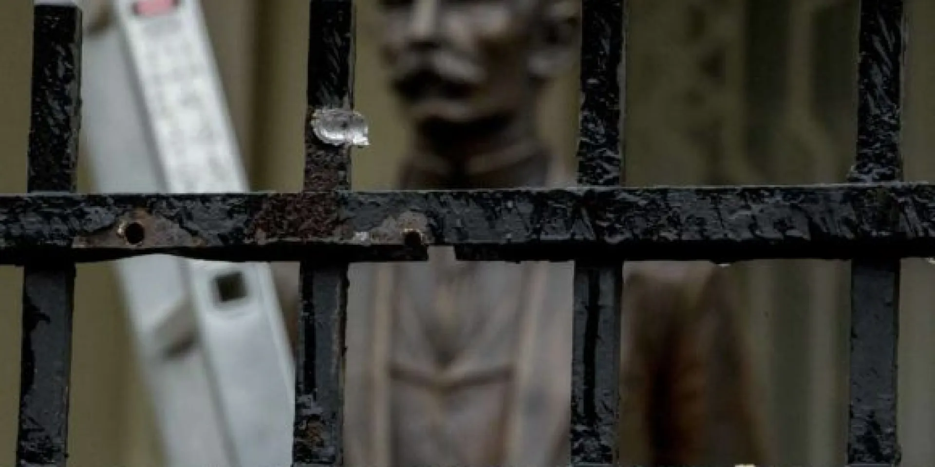 Una estatua del héroe de la independencia cubana José Martí está detrás de una cerca que ha sido perforada con agujeros de bala. Foto: AP.