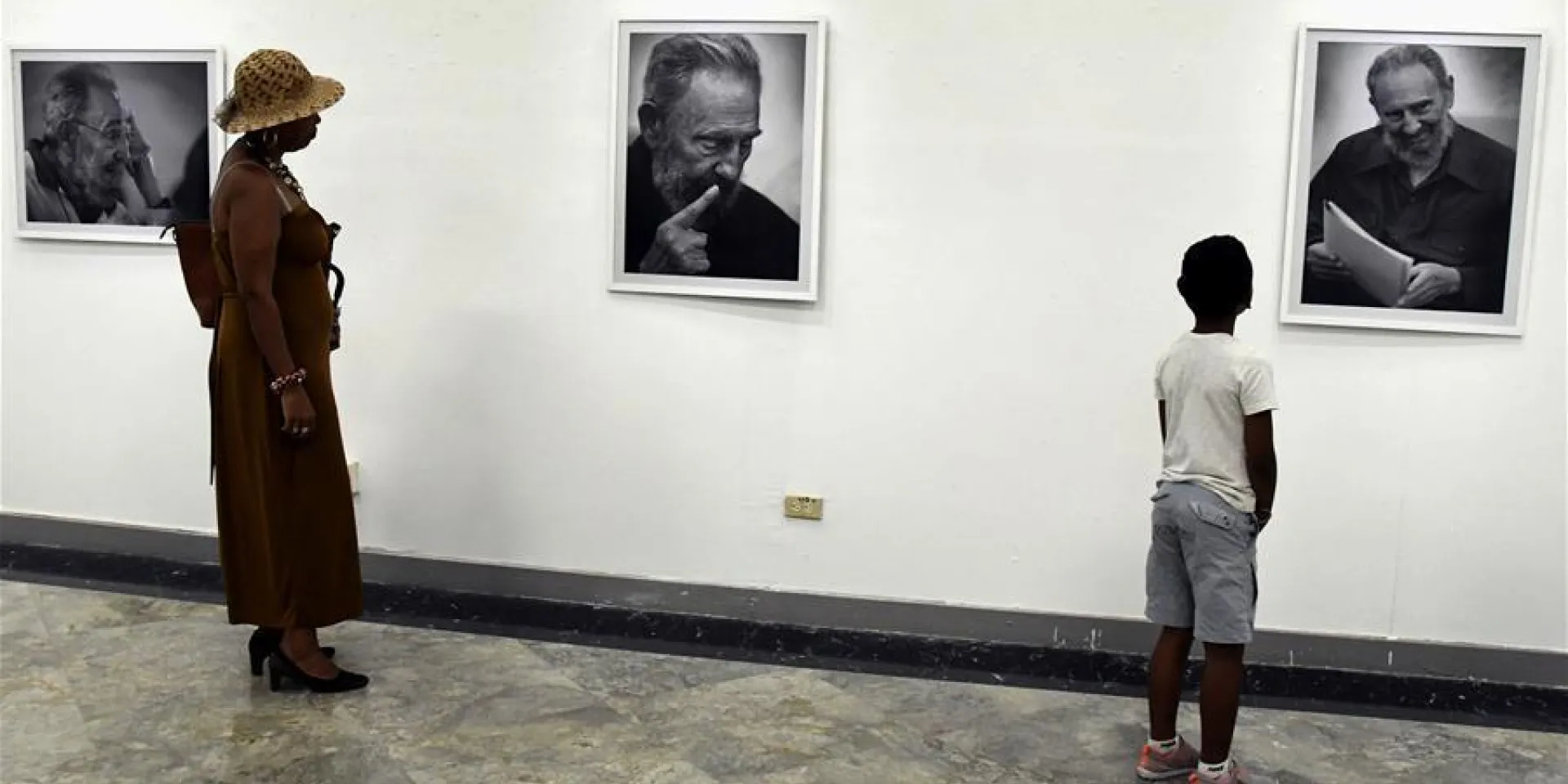 Personas visitan la exposición fotográfica "El rostro de la historia" en homenaje al fallecido ex presidente cubano, Fidel Castro, en La Habana.