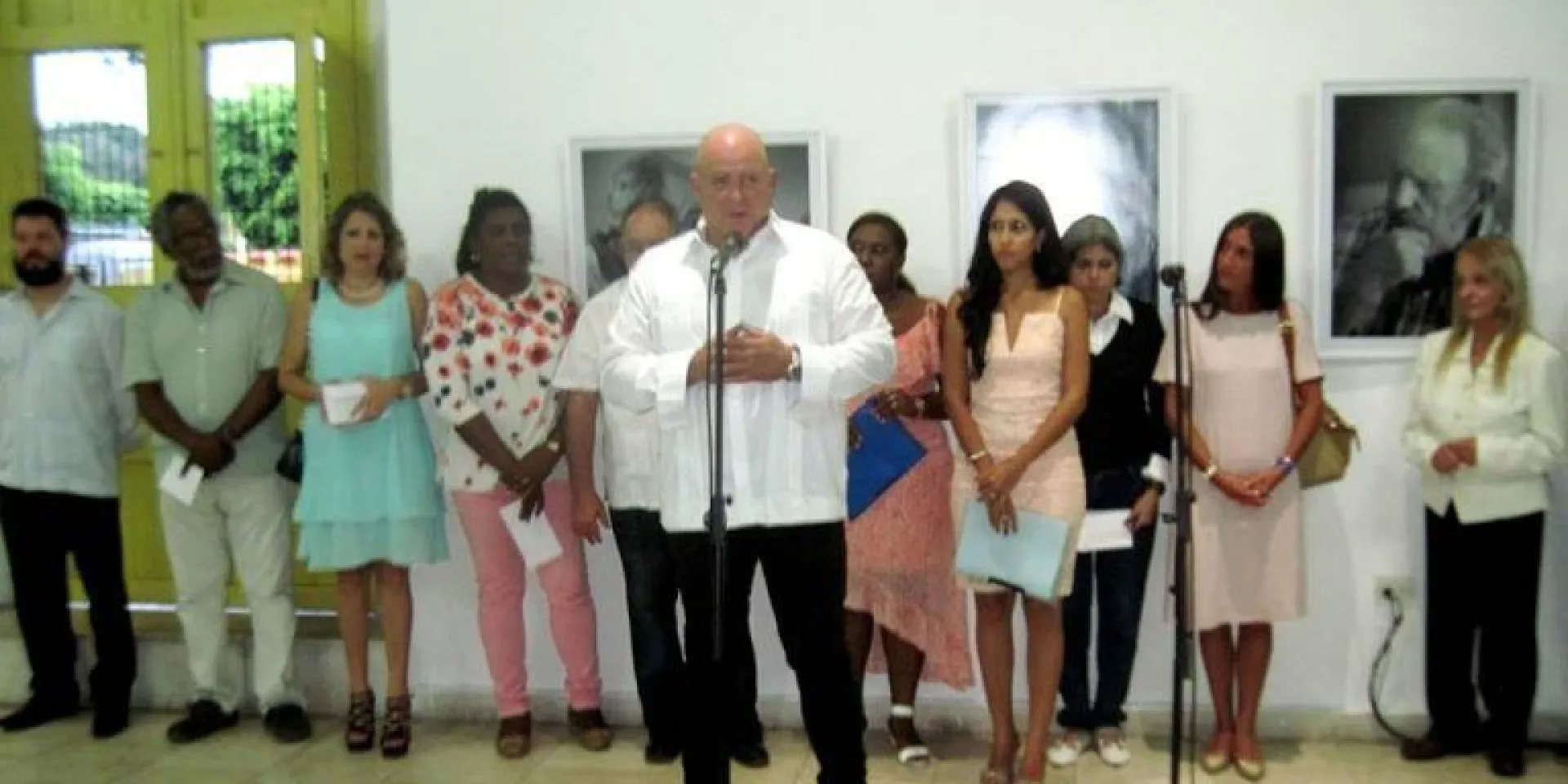 Alex Castro habla en la inauguración de su expo en Santiago. Detrás, las máximas autoridades de Santiago de Cuba, la escritora Teresa Melo y famniliares del Comandante en Jefe. Foto: Miguel Ángel Gaínza
